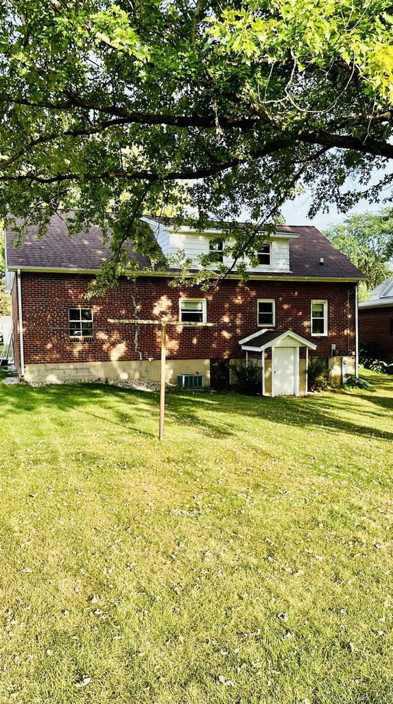 exterior space with a lawn and central AC