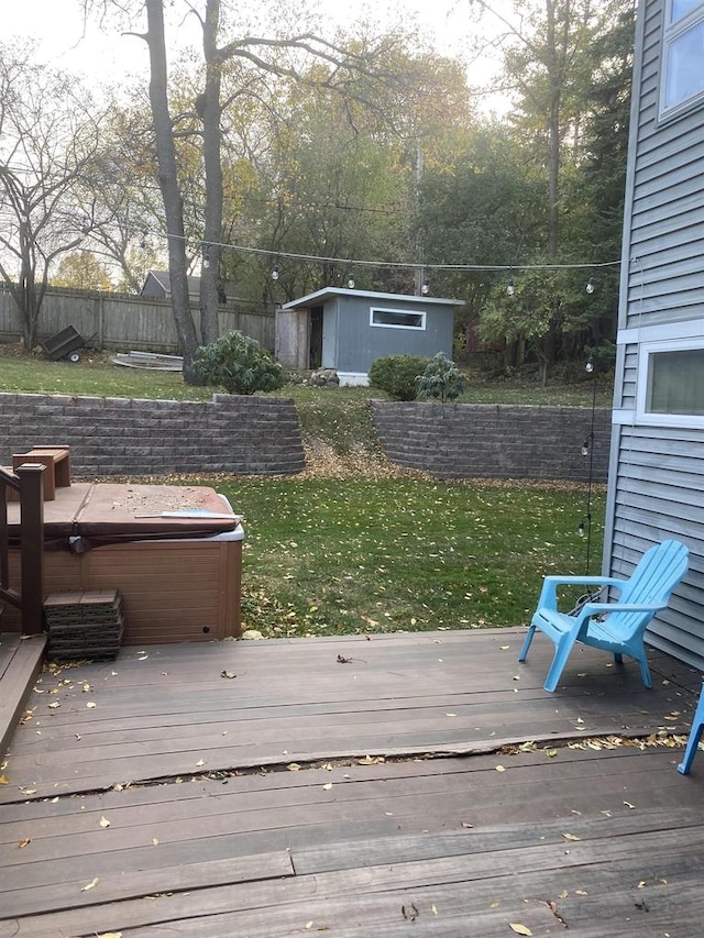 wooden deck with a hot tub and a lawn