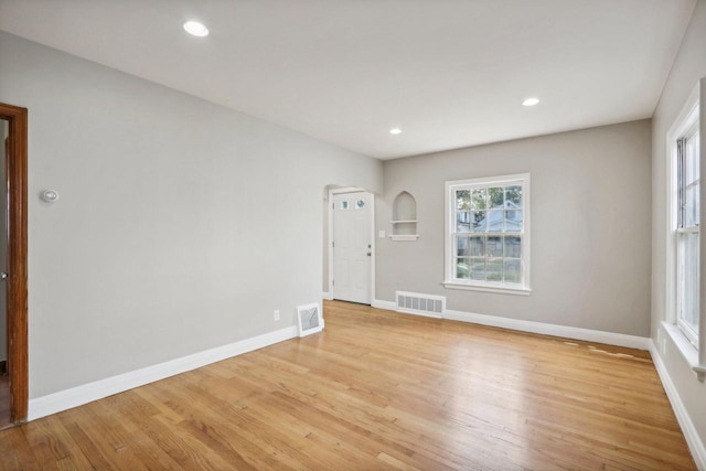 empty room with light wood-type flooring and plenty of natural light