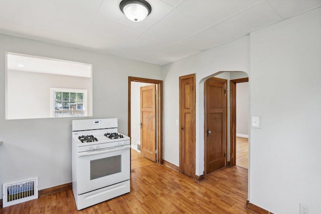 kitchen featuring wood-type flooring and white gas stove