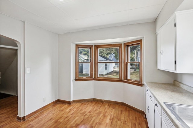 interior space featuring white cabinets, sink, and light hardwood / wood-style floors