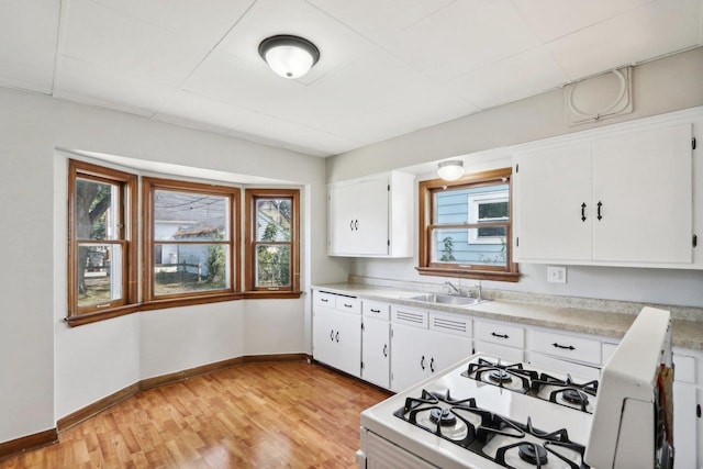 kitchen featuring plenty of natural light, light hardwood / wood-style floors, and white cabinetry