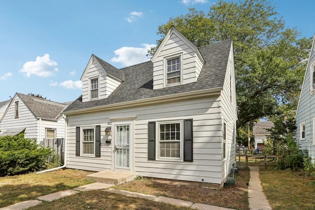 cape cod-style house featuring a front yard