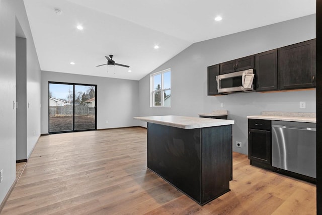 kitchen featuring a wealth of natural light, light wood-type flooring, appliances with stainless steel finishes, and a center island