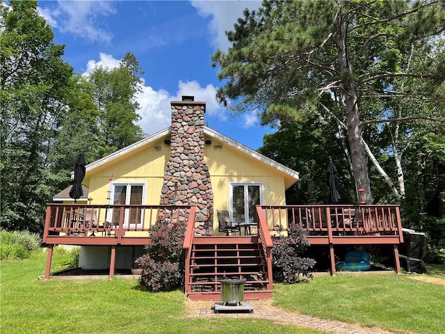 back of property featuring a deck and a yard