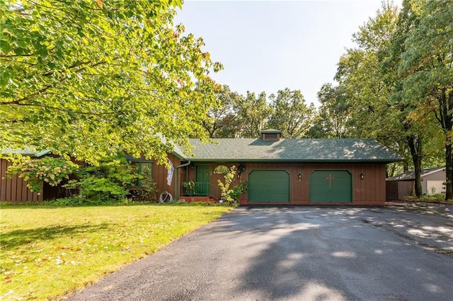 ranch-style home with a garage and a front lawn