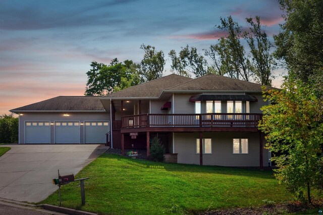 view of front of property with a garage, a wooden deck, and a yard