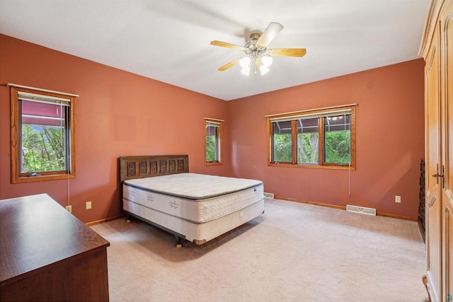 unfurnished bedroom with multiple windows, carpet, and ceiling fan