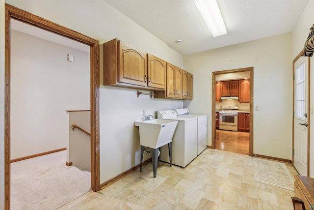 laundry room featuring separate washer and dryer and cabinets