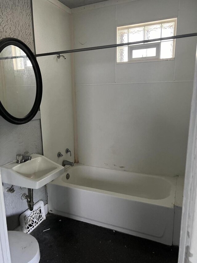 bathroom with toilet and tiled shower / bath