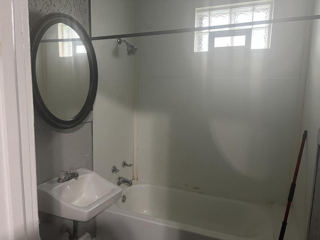 bathroom featuring tiled shower / bath combo and sink