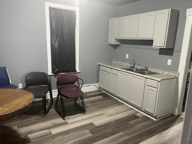 interior space featuring gray cabinetry, hardwood / wood-style flooring, and sink