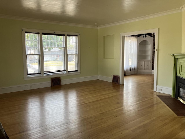 unfurnished living room featuring light wood-type flooring and ornamental molding