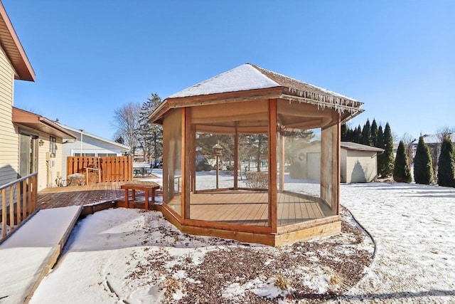 snow covered deck with a sunroom