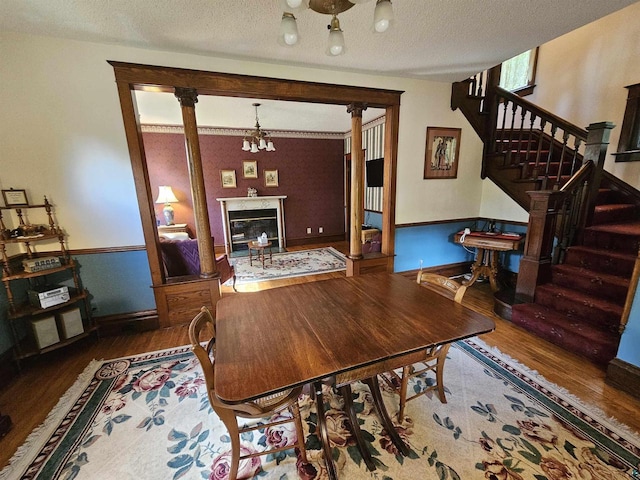 dining room with a notable chandelier, a textured ceiling, and hardwood / wood-style flooring