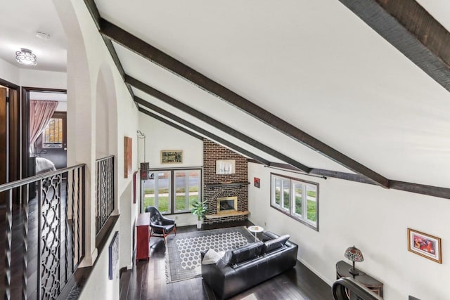 5302 Arapahoe Ln, Madison, WI 53704 - living room featuring a brick fireplace, wood finished floors, baseboards, vaulted ceiling with beams, and arched walkways