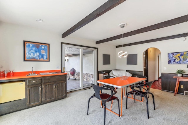 carpeted dining room featuring beam ceiling and indoor bar