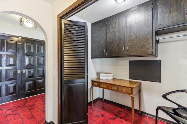 5302 Arapahoe Ln, Madison, WI 53704 - kitchen with arched walkways, baseboards, and brick patterned floor