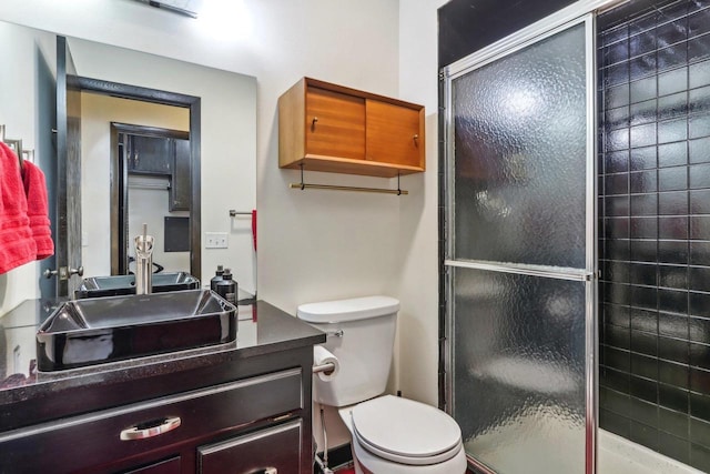 bathroom with toilet, an enclosed shower, and vanity