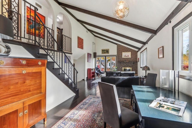 dining area featuring beam ceiling, dark wood-type flooring, a fireplace, and high vaulted ceiling