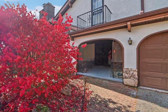 5302 Arapahoe Ln, Madison, WI 53704 - doorway to property featuring a chimney, a balcony, and stucco siding