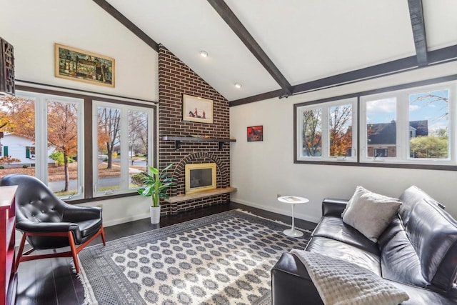 living room with a wealth of natural light, beamed ceiling, a fireplace, and dark hardwood / wood-style flooring