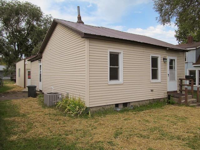 view of home's exterior featuring a lawn and central AC