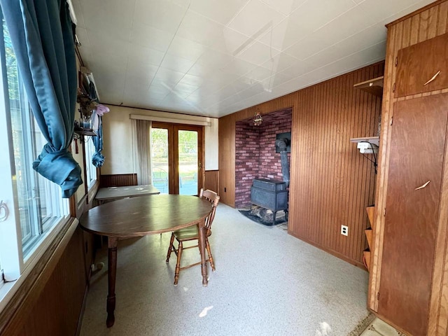 dining area featuring wooden walls and a wood stove