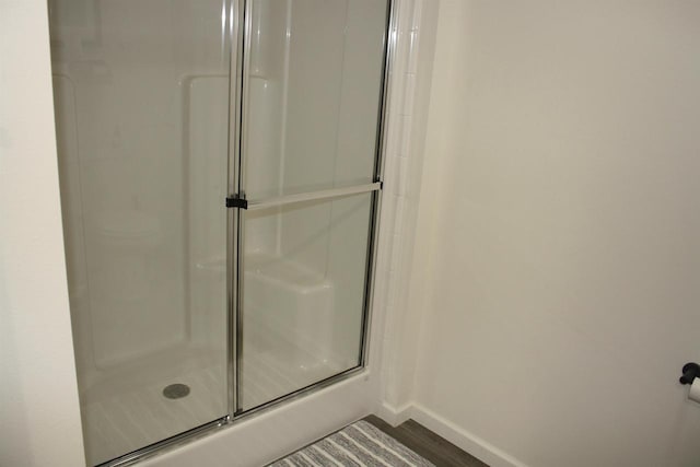 bathroom featuring walk in shower and wood-type flooring