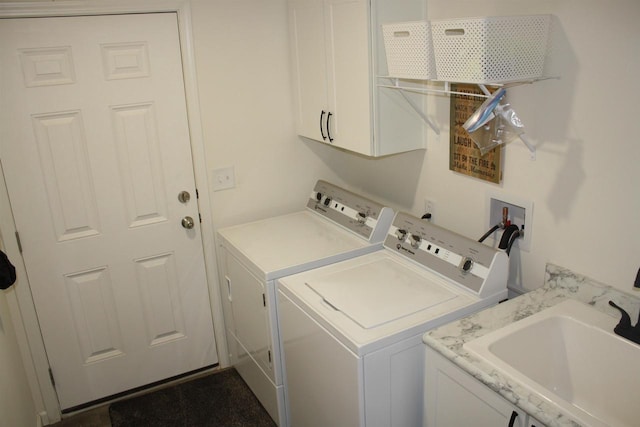 laundry area featuring washer and clothes dryer, sink, and cabinets