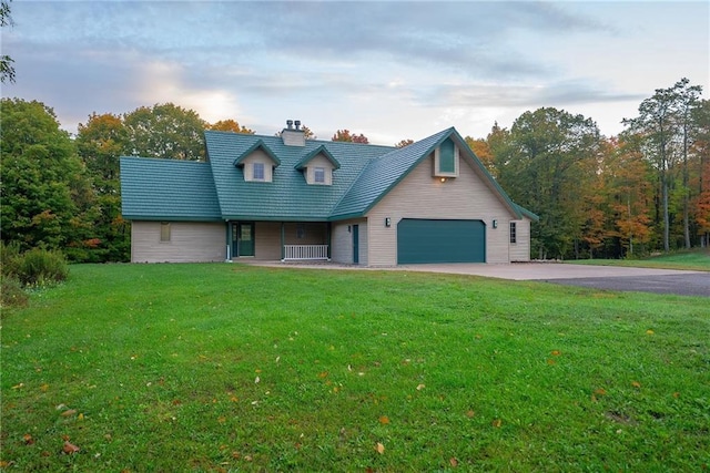 cape cod home featuring a garage and a front lawn