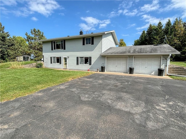 rear view of property with a garage and a lawn