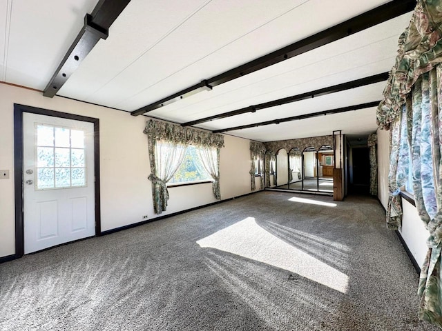 carpeted empty room with plenty of natural light and beam ceiling