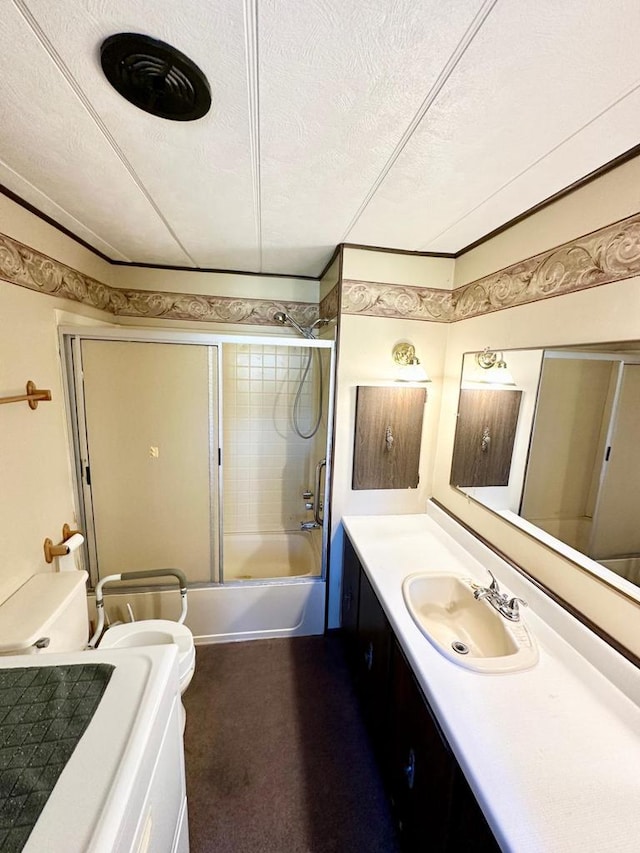 full bathroom featuring a textured ceiling, bathing tub / shower combination, vanity, and toilet