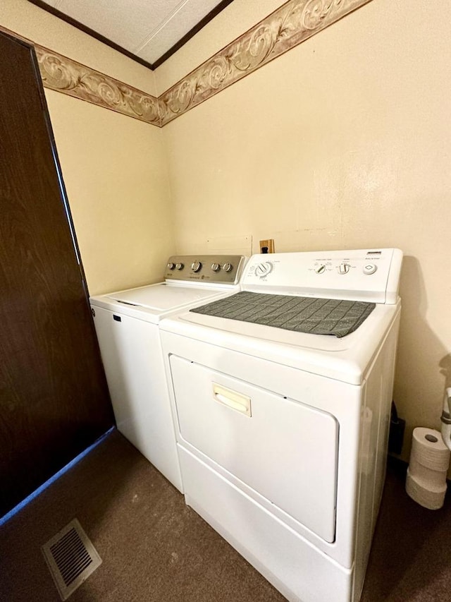 laundry room featuring dark carpet, a textured ceiling, and washing machine and dryer