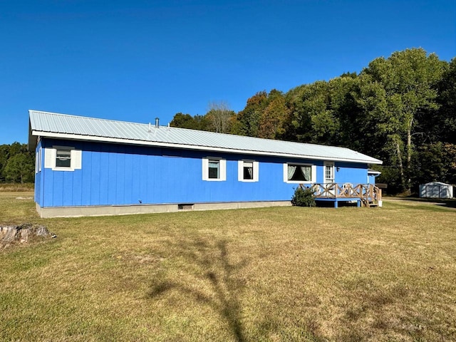 back of property featuring a lawn and a shed