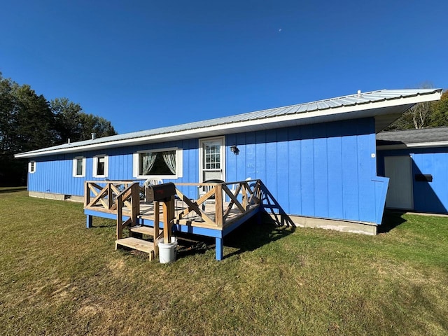 rear view of property featuring a yard and a deck