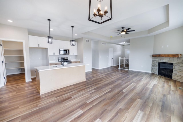 889 Red Hawk Dr, Milton, WI 53563 - kitchen featuring stainless steel microwave, open floor plan, light countertops, stove, and white cabinetry