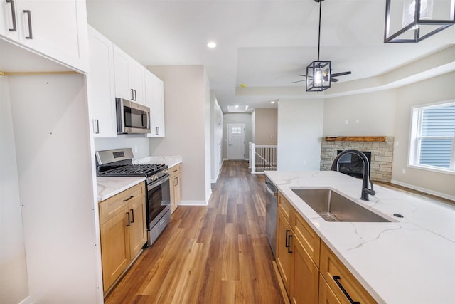 889 Red Hawk Dr, Milton, WI 53563 - kitchen with appliances with stainless steel finishes, a ceiling fan, wood finished floors, recessed lighting, and open floor plan