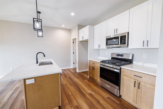889 Red Hawk Dr, Milton, WI 53563 - kitchen with appliances with stainless steel finishes, light stone countertops, dark wood-style floors, recessed lighting, and hanging light fixtures