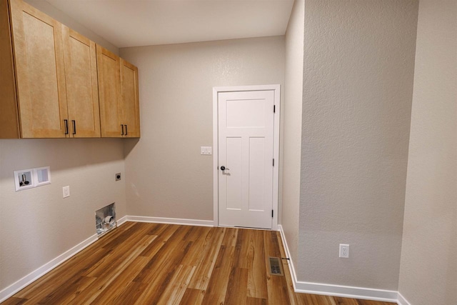 889 Red Hawk Dr, Milton, WI 53563 - washroom with hookup for an electric dryer, cabinet space, dark wood-type flooring, and hookup for a washing machine