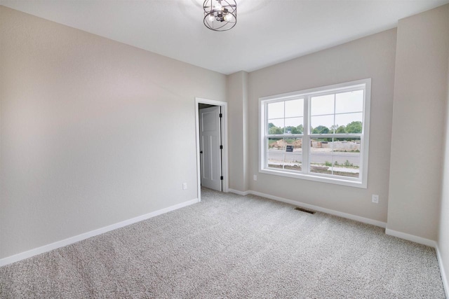 889 Red Hawk Dr, Milton, WI 53563 - spare room featuring carpet flooring and a chandelier