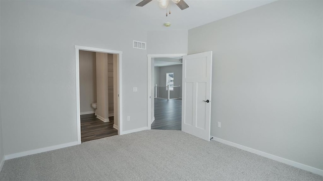 unfurnished bedroom with baseboards, visible vents, ceiling fan, carpet flooring, and connected bathroom