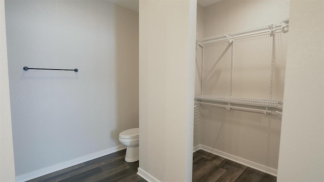 bathroom with baseboards, toilet, and wood finished floors