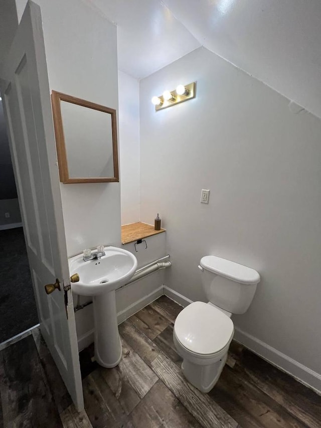 bathroom featuring wood-type flooring, lofted ceiling, and toilet