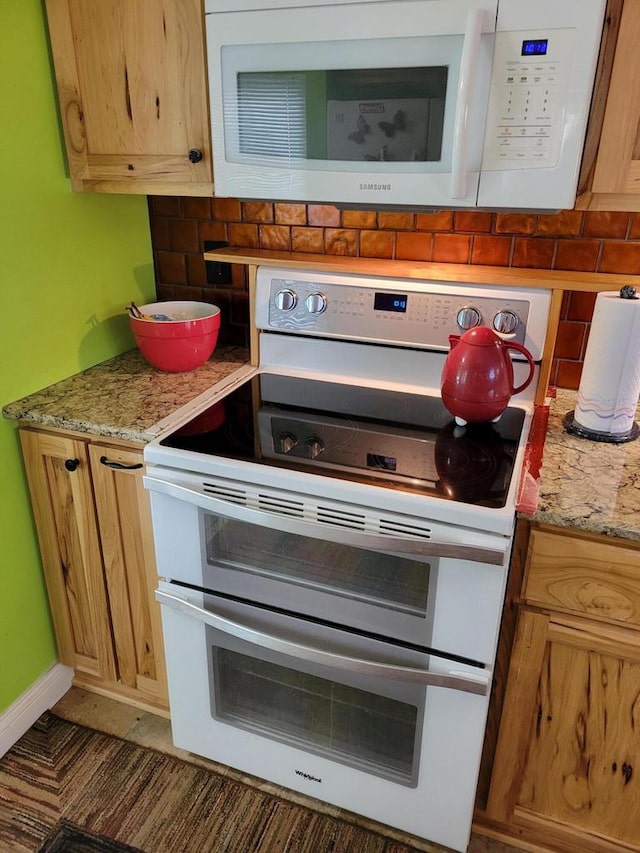 kitchen with white appliances and light stone countertops