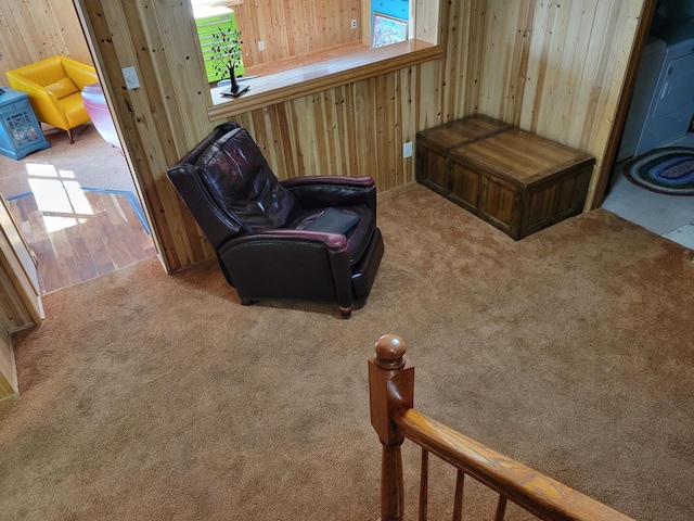 sitting room featuring carpet floors and wooden walls