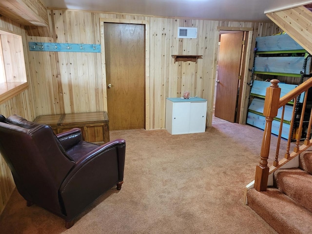 sitting room featuring carpet and wood walls