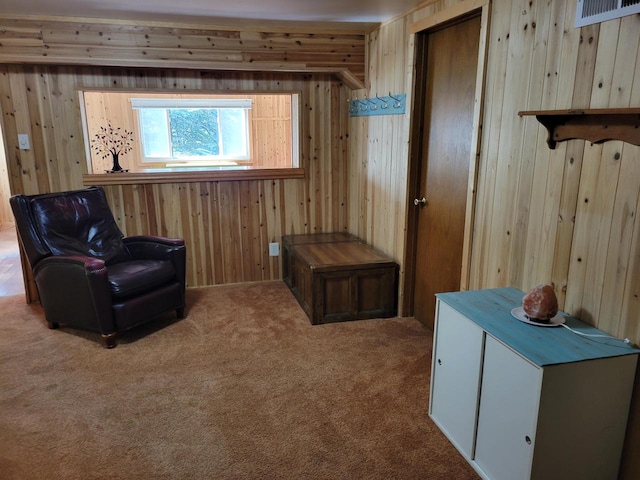 living area with wood walls and carpet floors