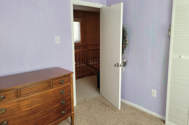 unfurnished bedroom featuring wooden walls and light colored carpet